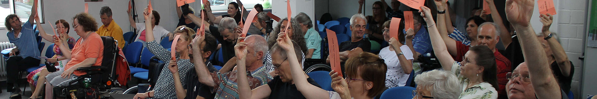 Menschen mit Stimmzetteln bei einer Abstimmung.